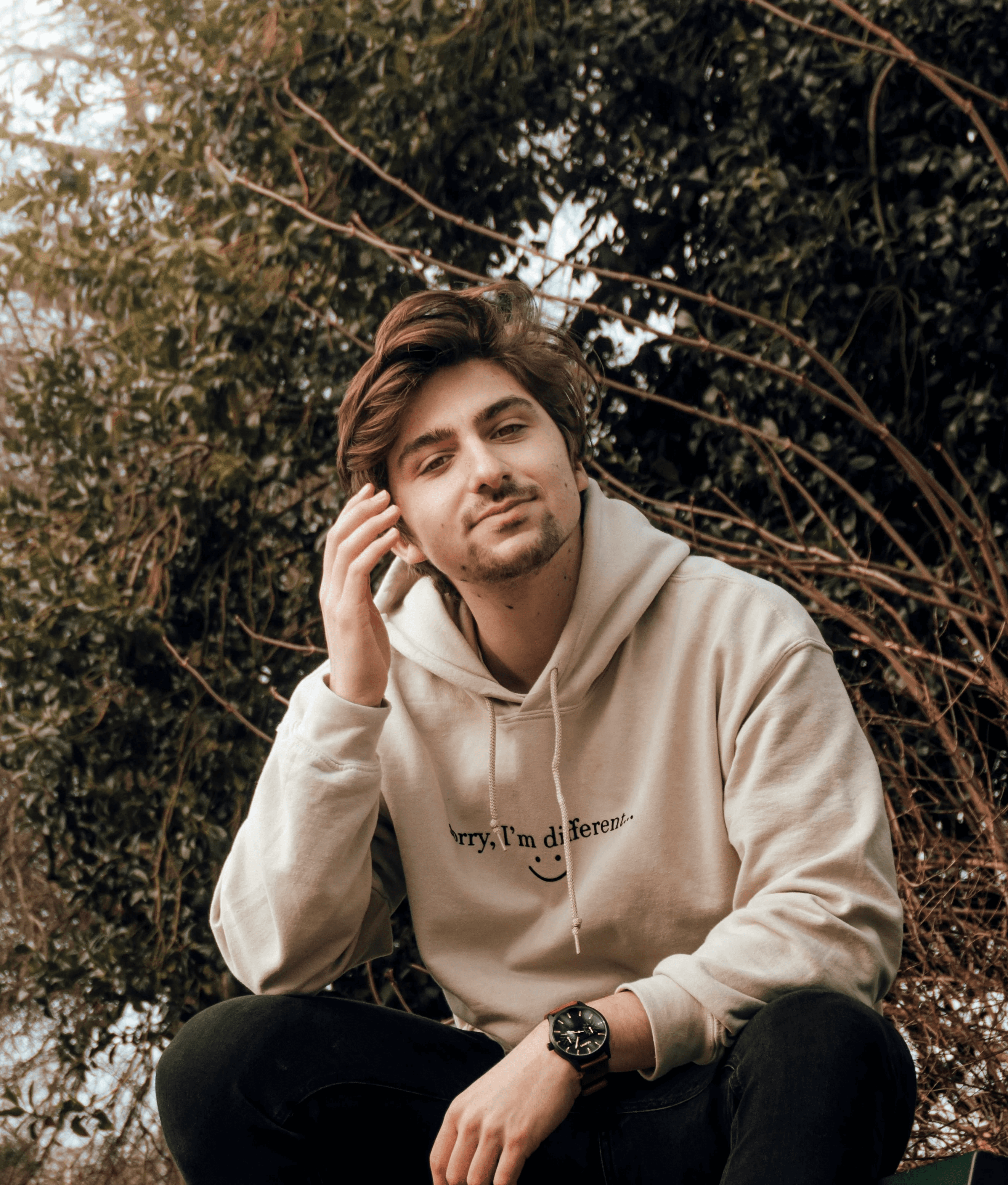 man in gray hoodie sitting on black bench